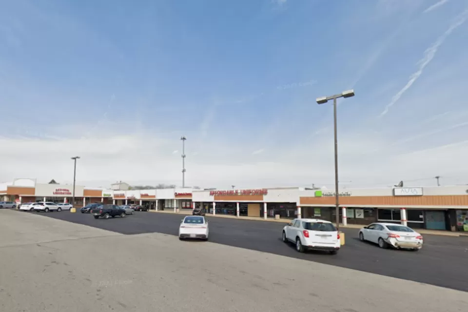Google Maps view of one-story shopping center with large parking lot.